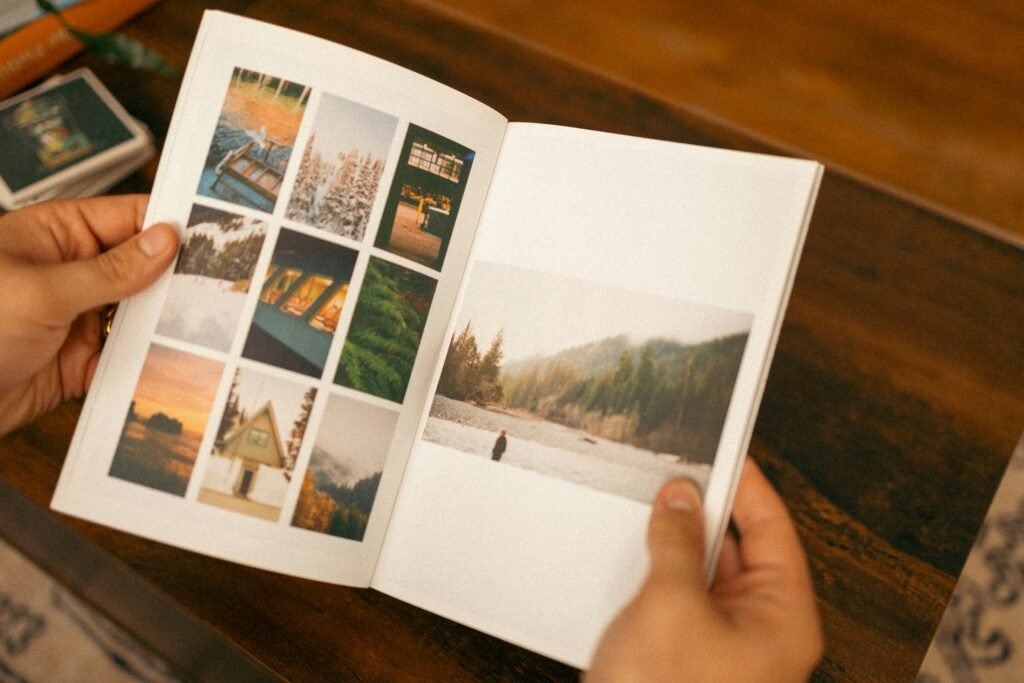 Hands holding an illustrated book with nature and landscape images.